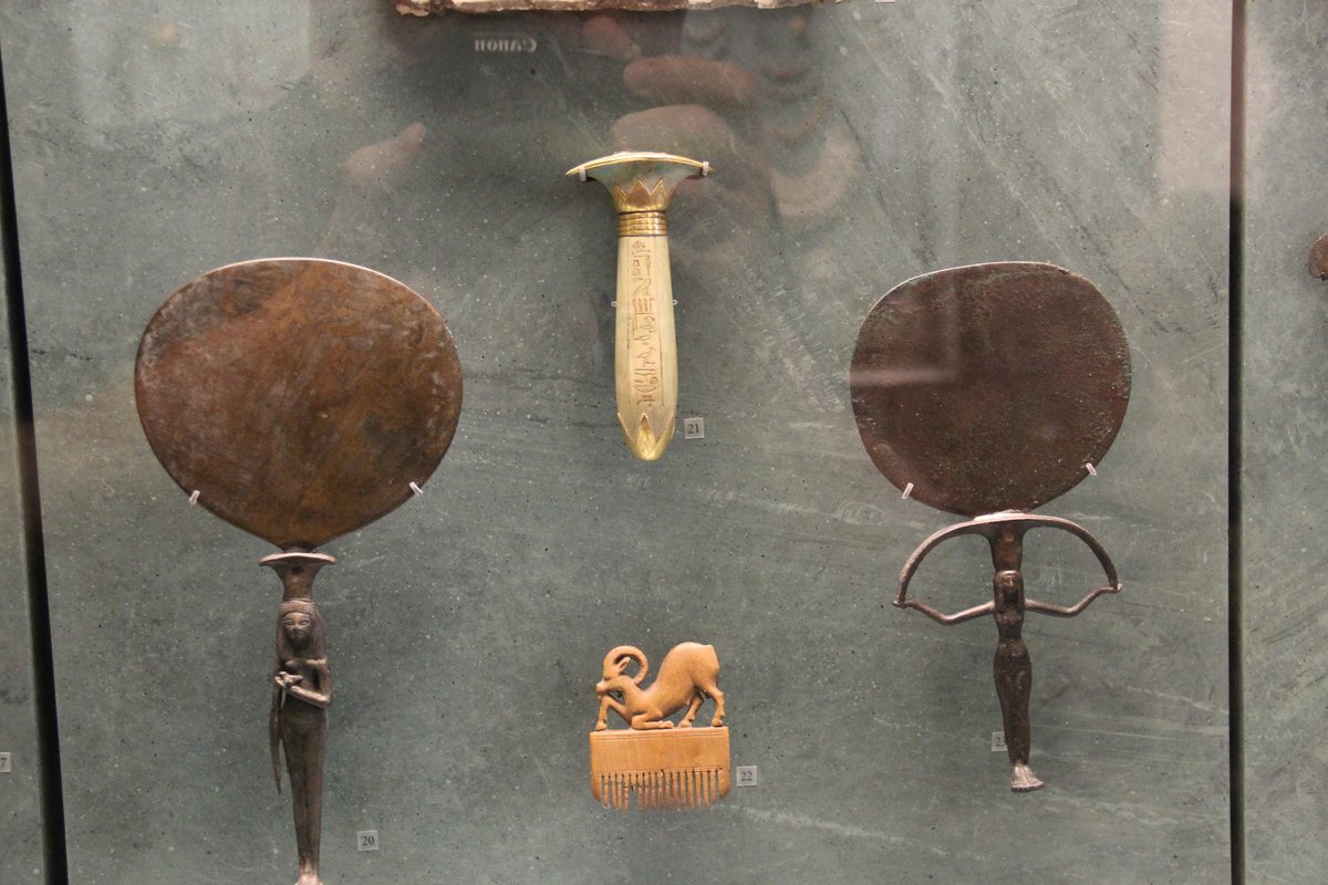 Ancient Egyptian bronze mirrors displayed together in a museum