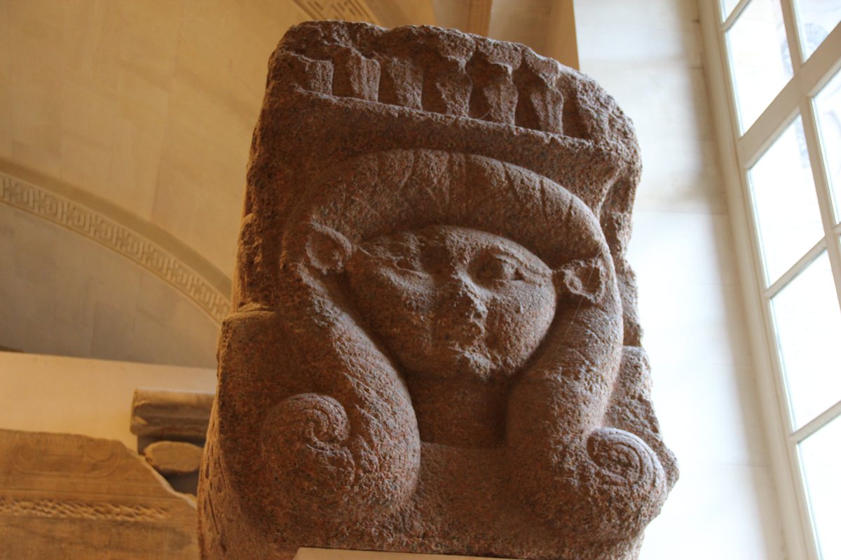 Ancient Egyptian stone statue head seen in a museum gallery